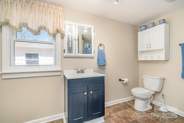full bathroom featuring toilet, vanity, and baseboards