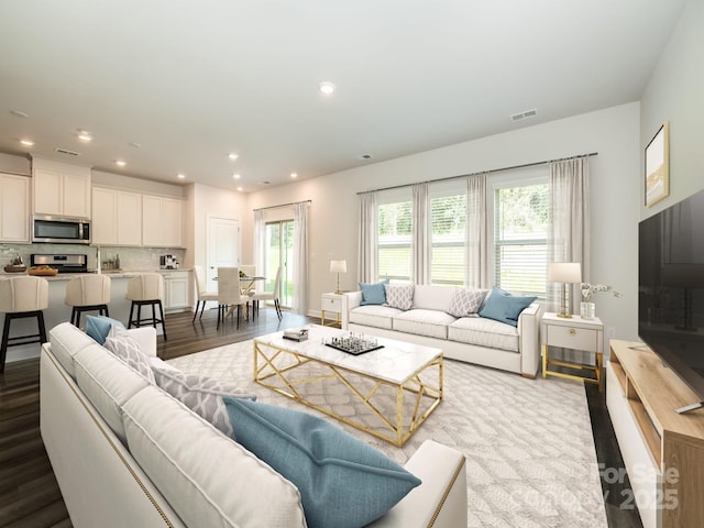 living area featuring recessed lighting, dark wood-style flooring, and visible vents