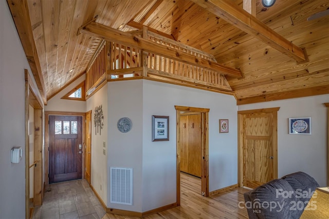 foyer featuring wood finished floors, wood ceiling, visible vents, baseboards, and beamed ceiling