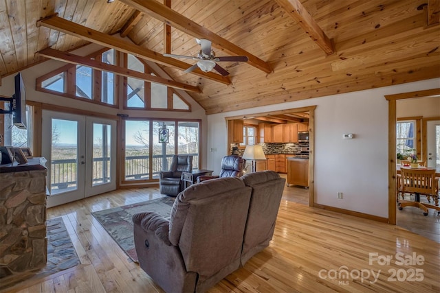 living area featuring french doors, beamed ceiling, wooden ceiling, and light wood-style floors