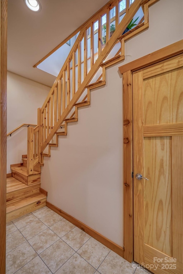 stairs featuring tile patterned flooring and baseboards