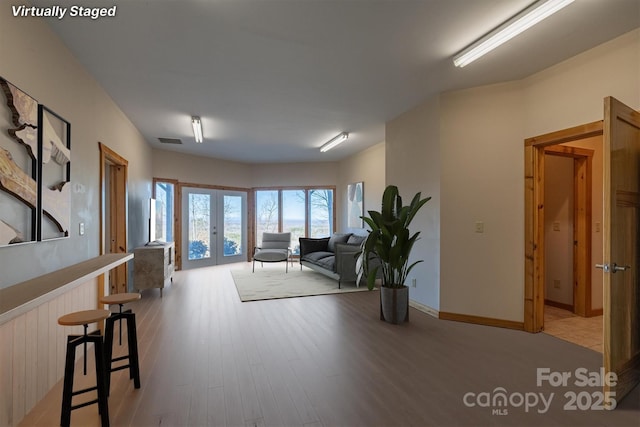 interior space featuring french doors, light wood-style flooring, and visible vents