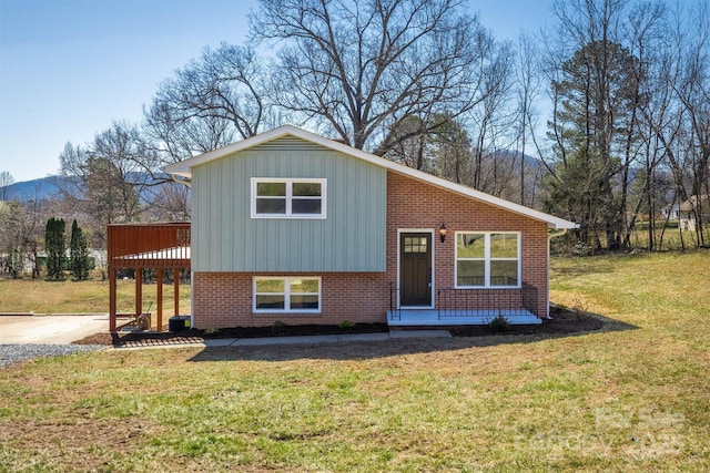 tri-level home featuring brick siding and a front yard