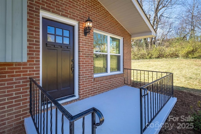 doorway to property featuring brick siding