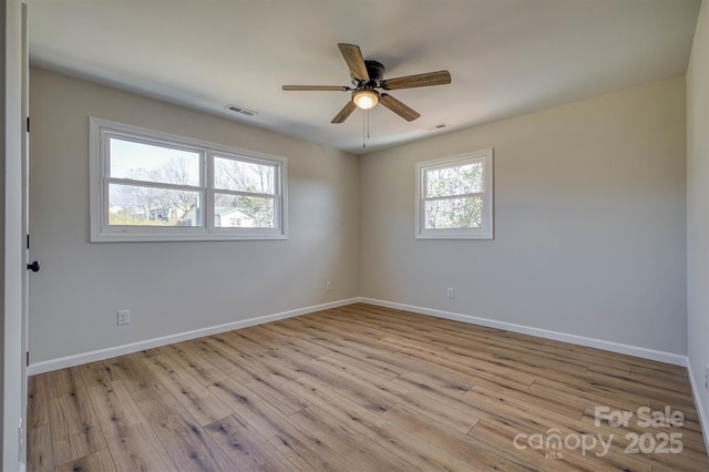 empty room with visible vents, baseboards, light wood-style floors, and ceiling fan