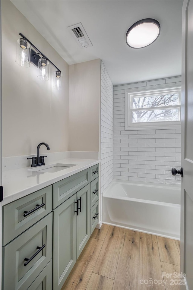 full bathroom featuring visible vents, vanity, and wood finished floors