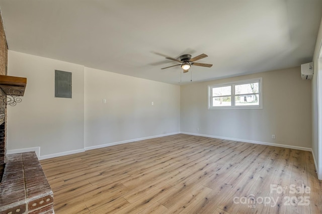 unfurnished living room featuring electric panel, light wood-style flooring, a ceiling fan, and a wall unit AC