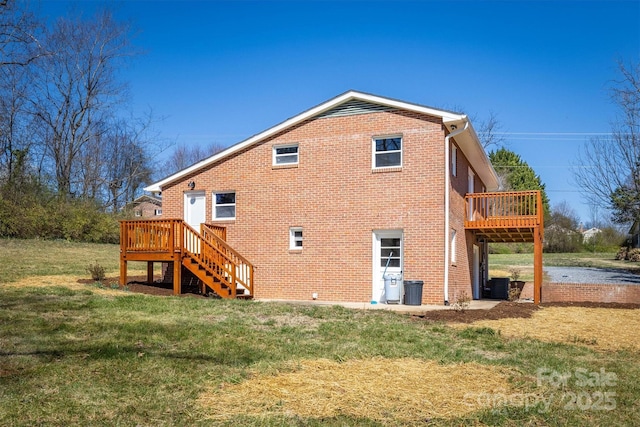 back of house featuring brick siding, a deck, stairs, and a yard