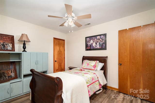 bedroom with baseboards, visible vents, ceiling fan, and wood finished floors