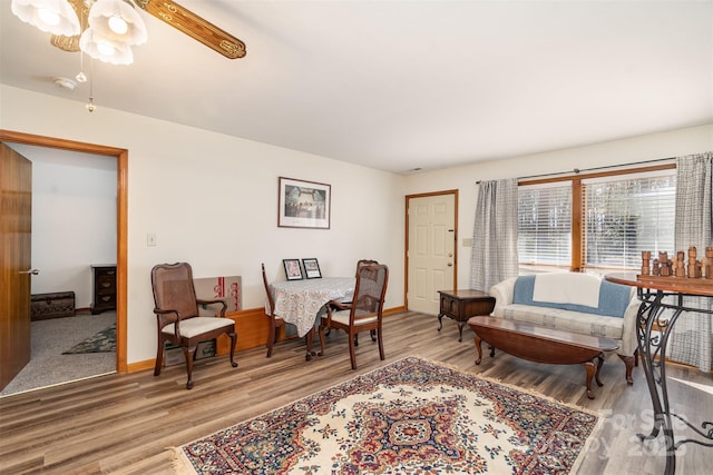 sitting room featuring ceiling fan, light wood-style flooring, and baseboards