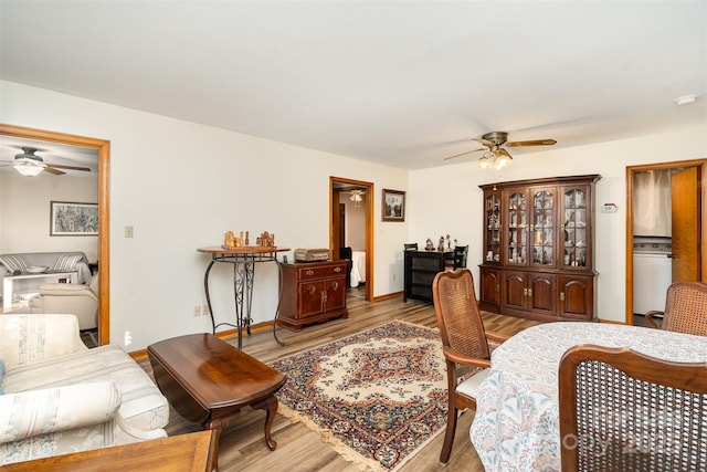 bedroom featuring washer / dryer, baseboards, and wood finished floors