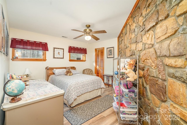 bedroom featuring ceiling fan, light wood finished floors, a closet, and visible vents