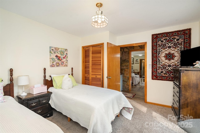 bedroom with a closet, carpet flooring, and baseboards