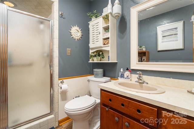 full bathroom with toilet, a stall shower, and vanity