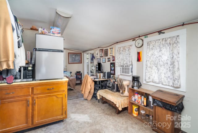 kitchen featuring light countertops, freestanding refrigerator, and brown cabinets