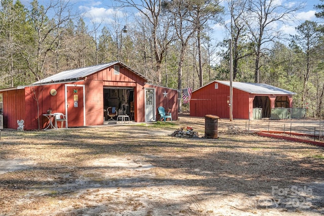 view of pole building with dirt driveway