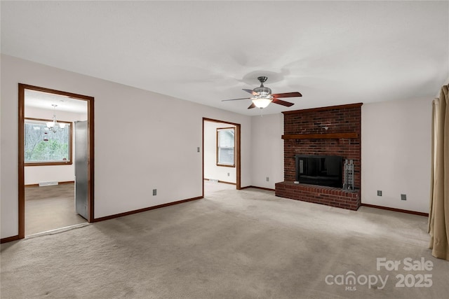 unfurnished living room featuring carpet flooring, a fireplace, baseboards, and ceiling fan with notable chandelier