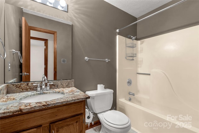 bathroom with washtub / shower combination, vanity, toilet, and a textured ceiling