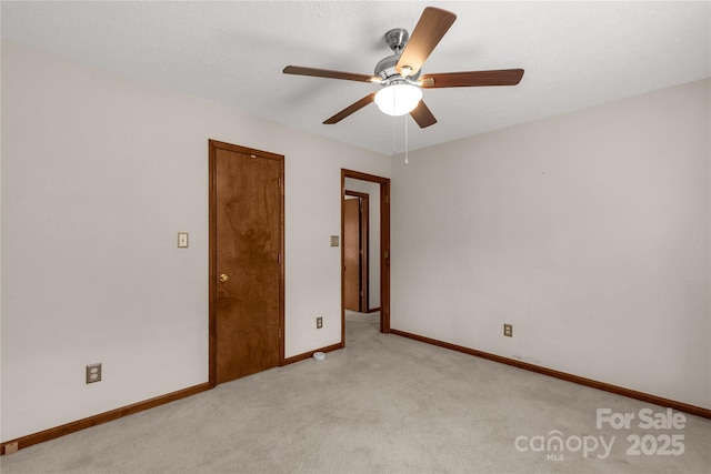 unfurnished room featuring light carpet, ceiling fan, and baseboards