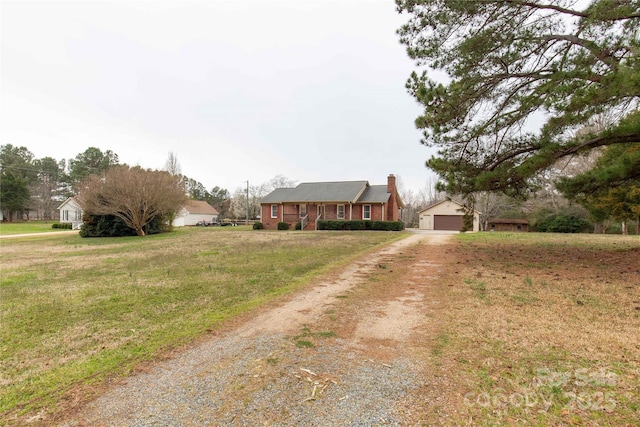 view of front of house featuring a garage, brick siding, an outdoor structure, a chimney, and a front yard