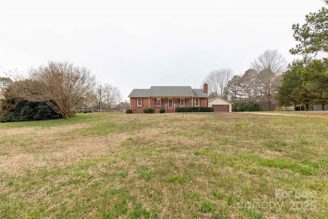 view of front of property featuring a garage, brick siding, a chimney, and a front lawn