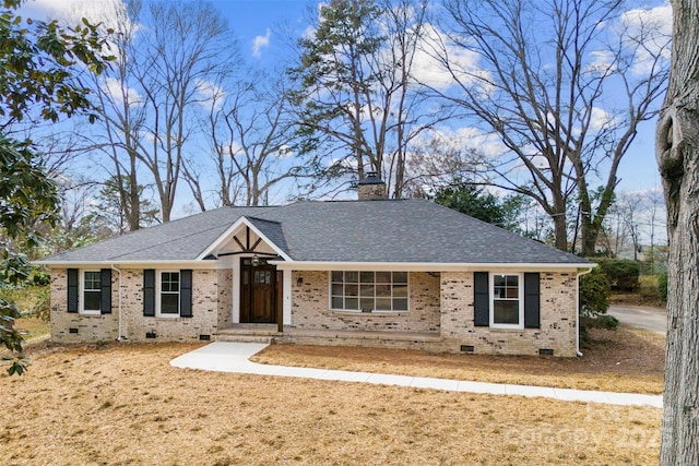 ranch-style house featuring crawl space, roof with shingles, a chimney, and brick siding