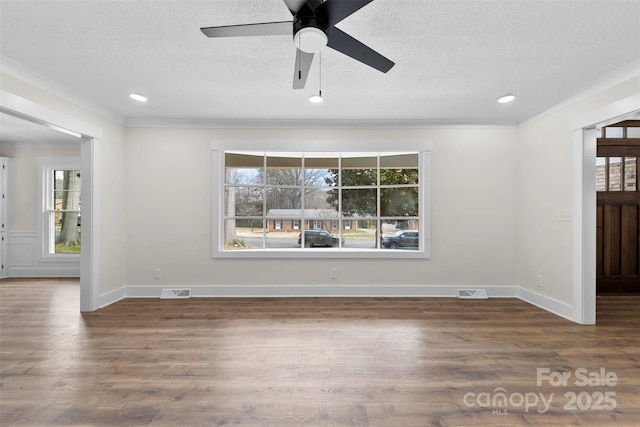 interior space with baseboards, a textured ceiling, visible vents, and wood finished floors