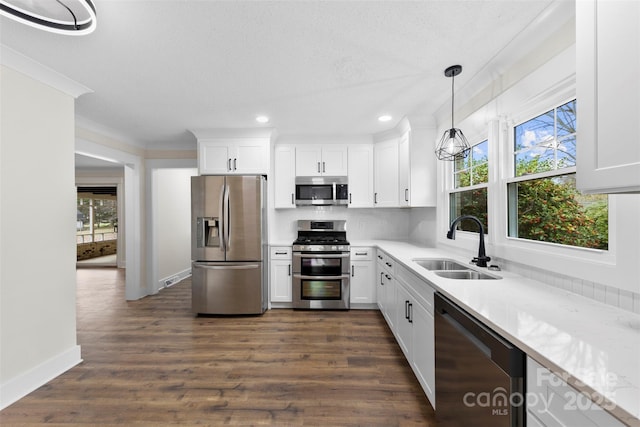 kitchen with stainless steel appliances, dark wood finished floors, white cabinetry, and a sink