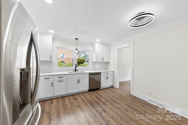 kitchen featuring visible vents, dark wood finished floors, stainless steel appliances, white cabinetry, and a sink