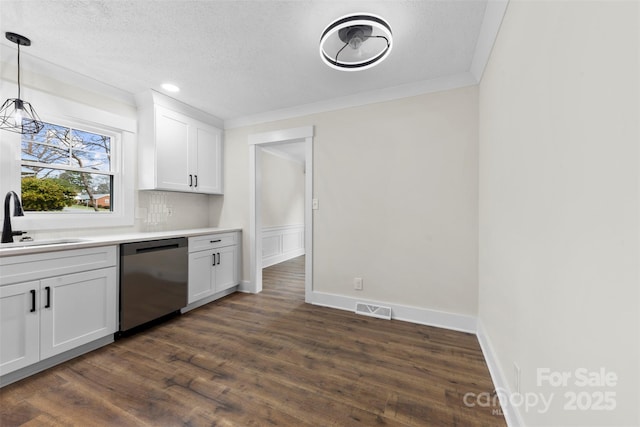 kitchen featuring visible vents, dark wood-type flooring, stainless steel dishwasher, white cabinetry, and a sink