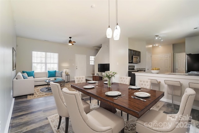 dining room with wood finished floors, a ceiling fan, and baseboards