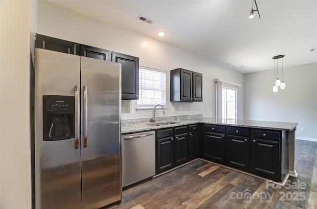 kitchen with visible vents, dark cabinetry, appliances with stainless steel finishes, and a sink