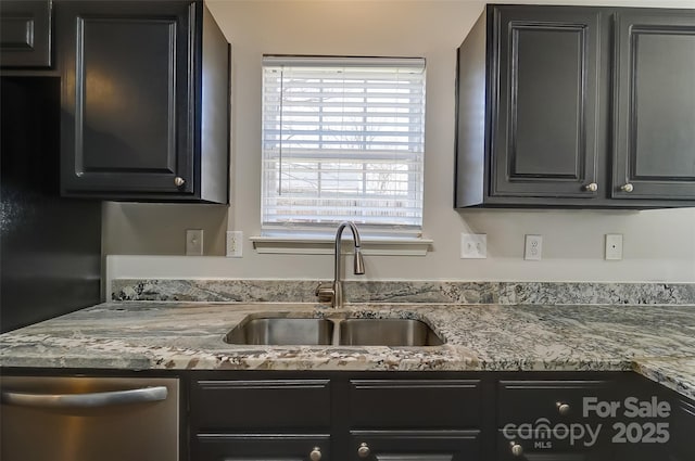 kitchen featuring stone counters, a sink, and dishwasher