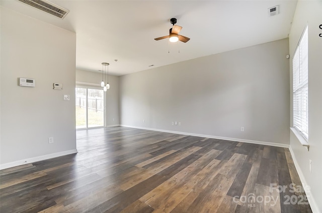 unfurnished room featuring dark wood finished floors, visible vents, and a ceiling fan