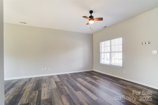 unfurnished room featuring visible vents, dark wood finished floors, baseboards, and ceiling fan