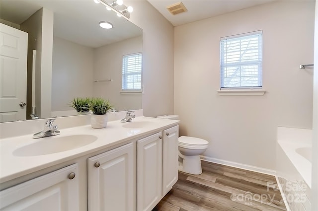 bathroom with a wealth of natural light, visible vents, and a sink