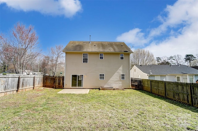 rear view of property with a fenced backyard, a lawn, and a patio