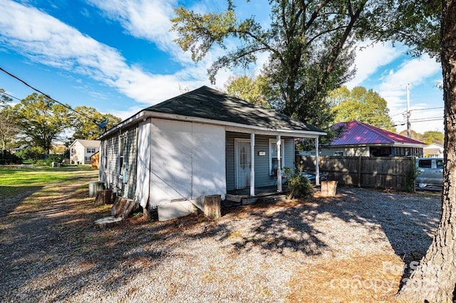 view of outbuilding with fence and a porch