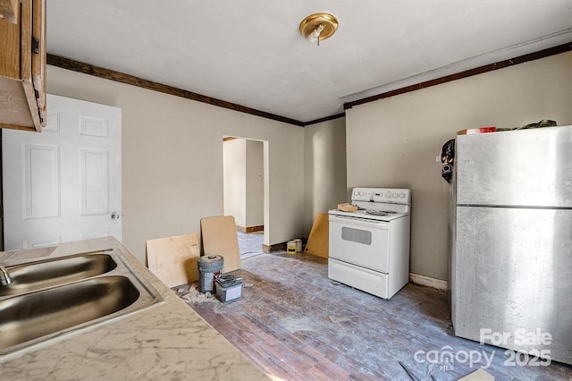 kitchen featuring white appliances, wood finished floors, a sink, light countertops, and crown molding