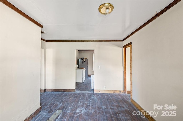 empty room featuring hardwood / wood-style flooring, baseboards, and crown molding