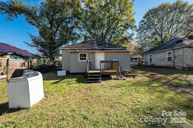 rear view of house featuring a deck, a yard, washer / clothes dryer, and fence