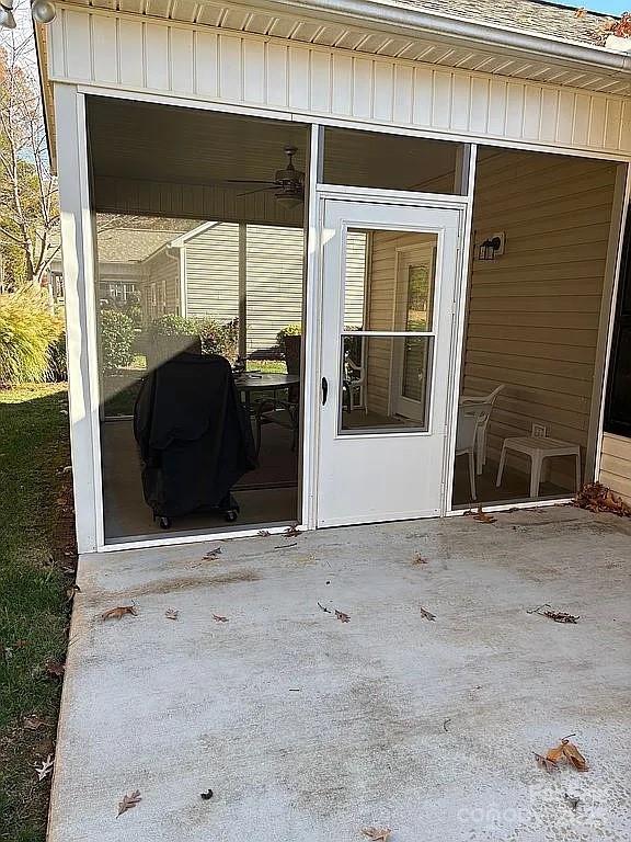 view of exterior entry featuring a carport and board and batten siding