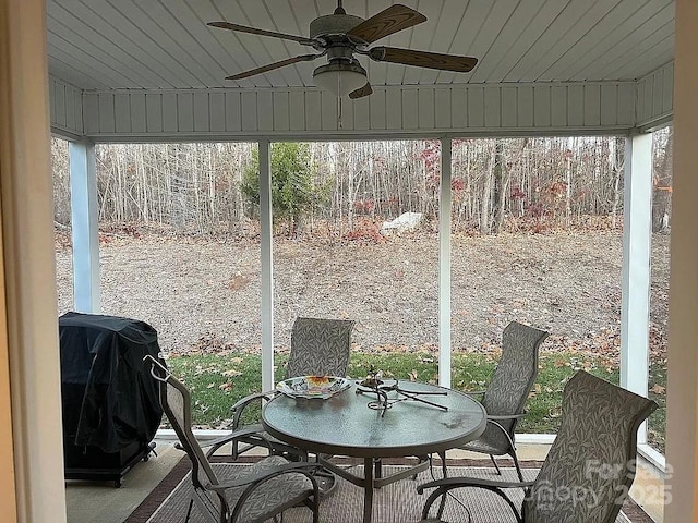 sunroom featuring wood ceiling and a ceiling fan