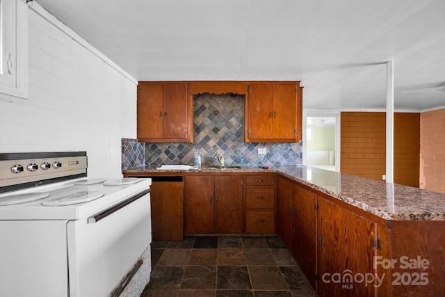 kitchen with a peninsula, a sink, brown cabinetry, tasteful backsplash, and white range with electric cooktop