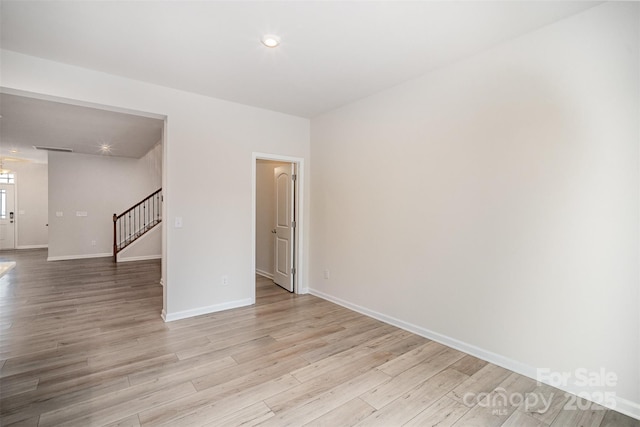 5532 Axil Ln, Charlotte, NC 28269 - empty room featuring light wood-type flooring, visible vents, baseboards, and stairs