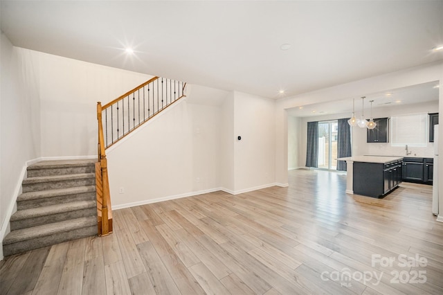 5532 Axil Ln, Charlotte, NC 28269 - unfurnished living room featuring light wood-style floors, stairs, baseboards, and recessed lighting