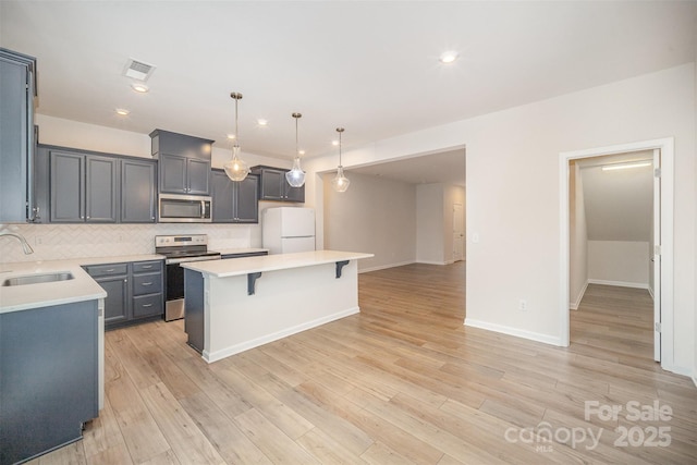 5532 Axil Ln, Charlotte, NC 28269 - kitchen featuring light countertops, visible vents, appliances with stainless steel finishes, a sink, and a kitchen breakfast bar