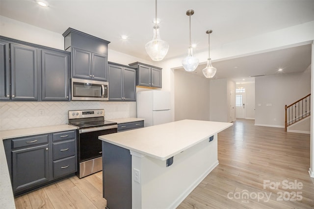 5532 Axil Ln, Charlotte, NC 28269 - kitchen with a center island, tasteful backsplash, light countertops, appliances with stainless steel finishes, and light wood-style floors