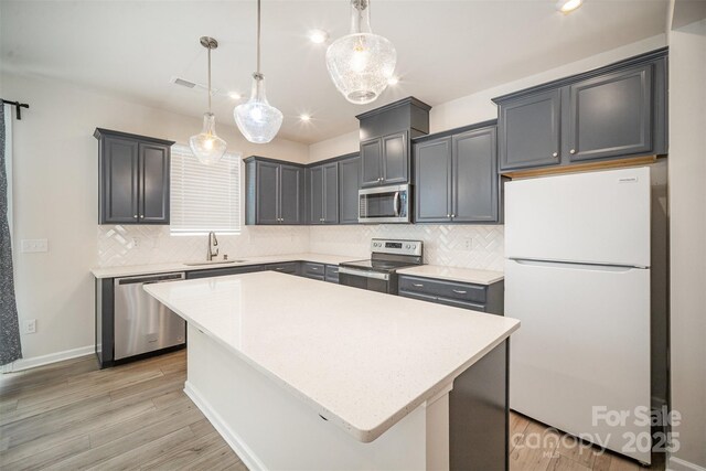 5532 Axil Ln, Charlotte, NC 28269 - kitchen featuring stainless steel appliances, light countertops, visible vents, a sink, and light wood-type flooring