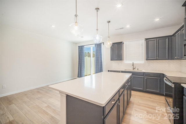 5532 Axil Ln, Charlotte, NC 28269 - kitchen with a sink, light wood-style floors, light countertops, electric range oven, and tasteful backsplash